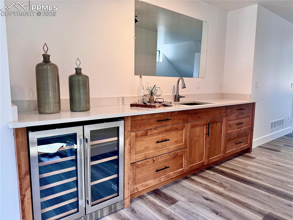 1282 South Crystal Road Lake George, CO 80827 - Photo 8 of 26 Indoor wet bar featuring beverage cooler and light wood finished floors