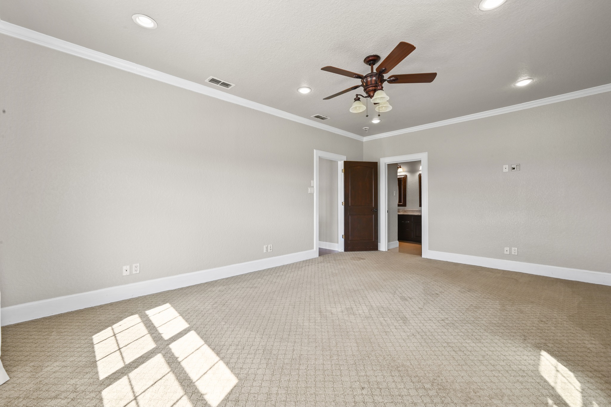 1175 Southern Way Luling, TX 78648 - Photo 27 of 40 A spacious primary bedroom features carpeted flooring and an adjacent bathroom.