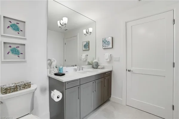 a spacious bathroom with a double vanity sink toilet and a mirror