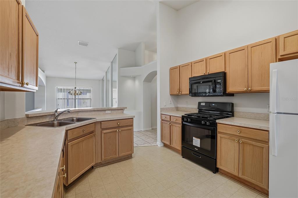 6935 Freeport Road Riverview, FL 33578 - Photo 13 of 51 a kitchen with stainless steel appliances granite countertop a sink stove microwave and refrigerator