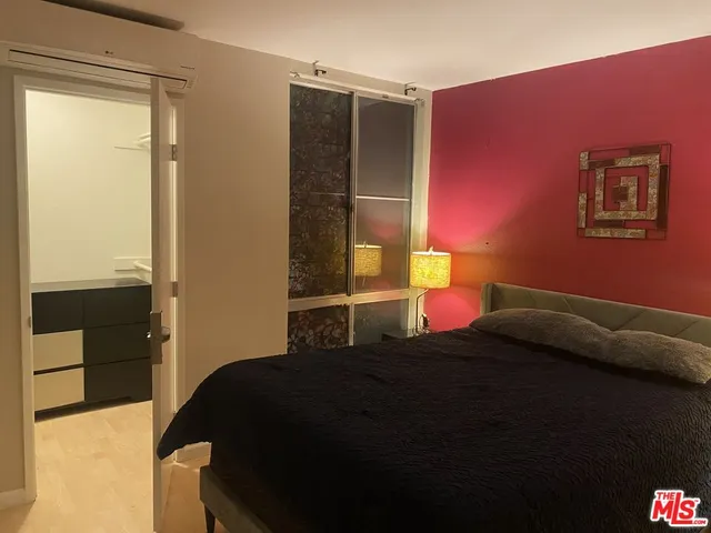 a bedroom with a bed and a lamp on dresser