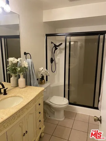 a bathroom with a granite countertop sink a toilet and shower