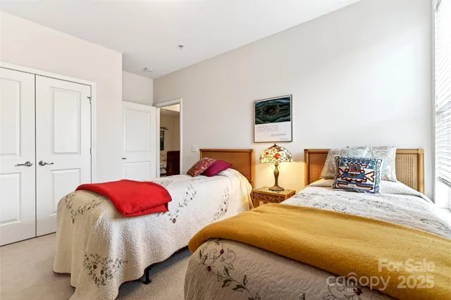 a bedroom with two beds and a chandelier