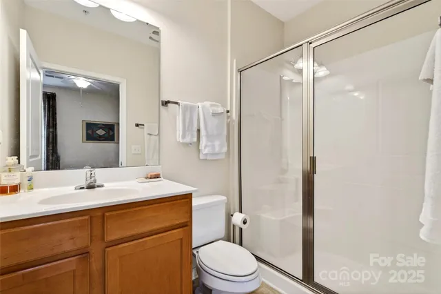 a bathroom with a sink toilet vanity and shower