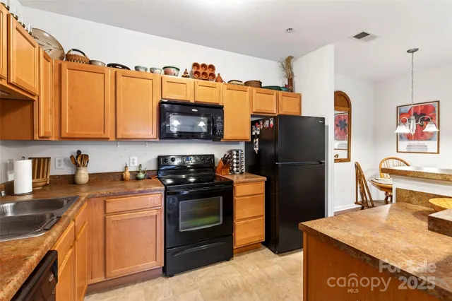 a kitchen with stainless steel appliances granite countertop a refrigerator stove top oven a sink and dishwasher