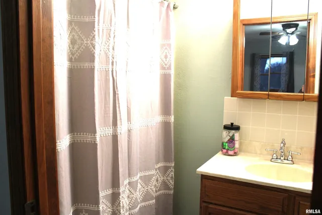 a bathroom with a tub sink and mirror