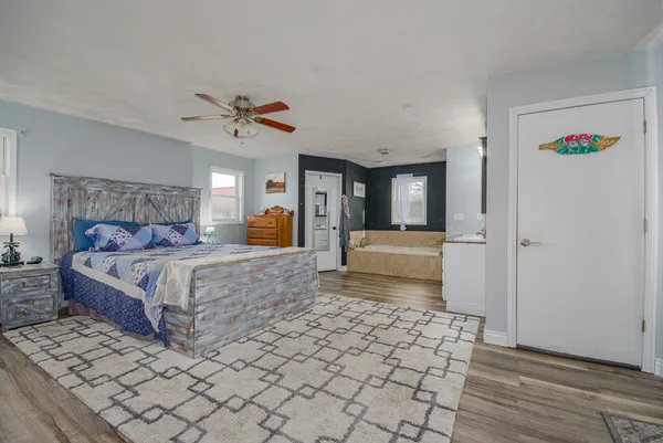 a view of a livingroom with a chandelier fan and wooden floor