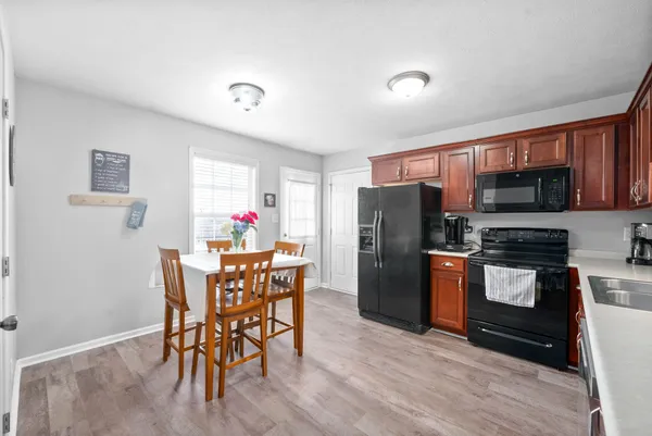 a kitchen with stainless steel appliances granite countertop a refrigerator and a dining table