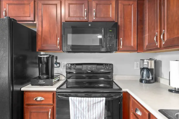 a kitchen with granite countertop wood cabinets and a stove top oven