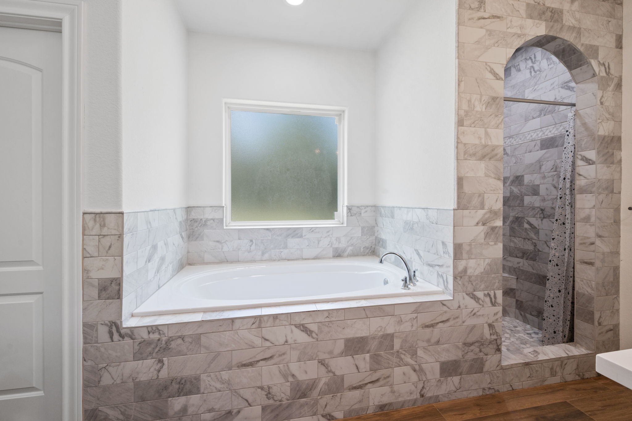 7815 Timber Switch Road Cleveland, TX 77328 - Photo 29 of 39 Elegant bathroom featuring a luxurious soaking tub and a stylish walk-in shower with marble tile accents.