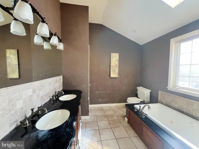 a bathroom with a tub sink and mirror