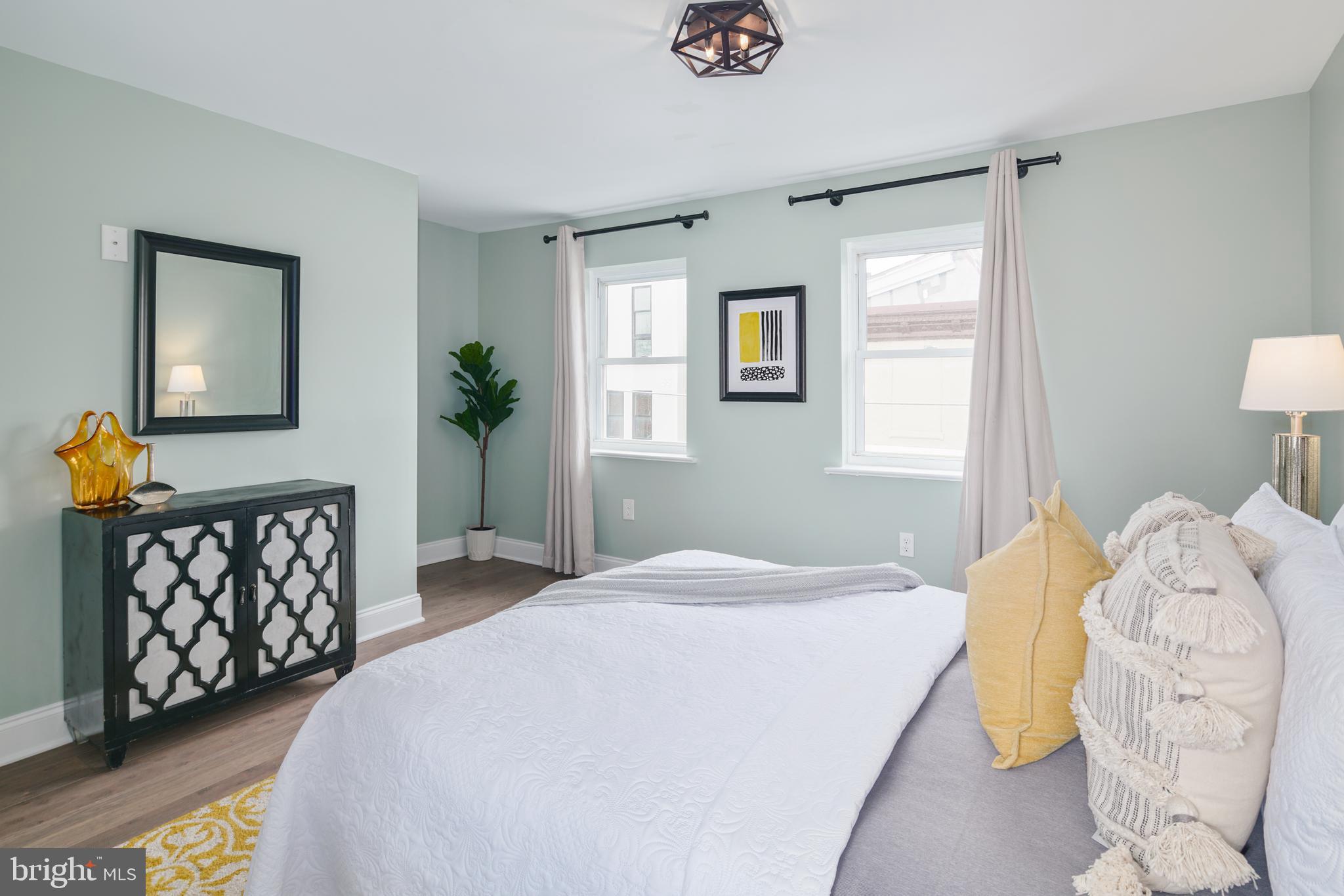 1443 East Oxford Street Philadelphia, PA 19125 - Photo 21 of 28 a bedroom with a bed a painting on the wall and a window