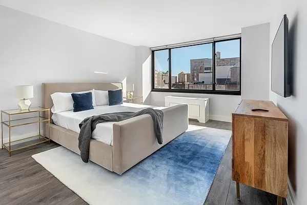 a bedroom with a large bed and a flat tv screen on a dresser