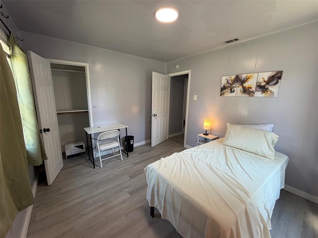 513 Shawnee Trace Grand Prairie, TX 75051 - Photo 19 of 32 Room featuring wood-finish flooring, a built-in closet with double doors, and a ceiling-mounted light fixture