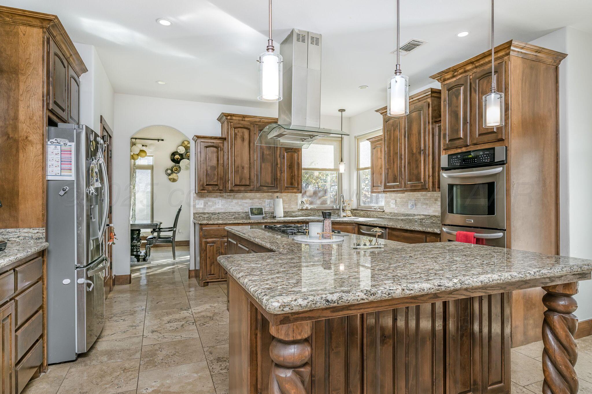 101 Pheasant Run Canyon, TX 79015 - Photo 11 of 39 a kitchen with stainless steel appliances granite countertop a sink a stove and a wooden cabinets