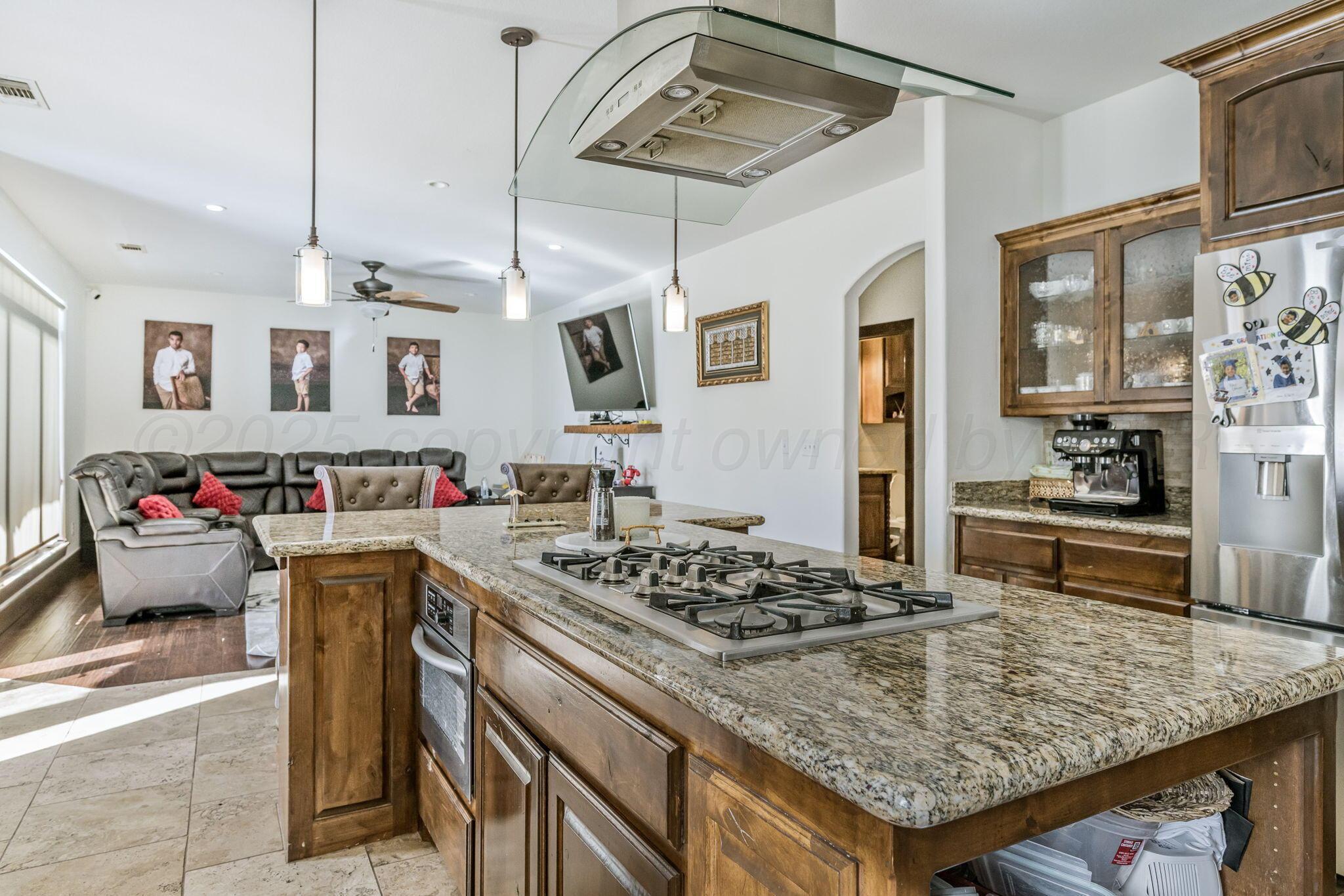 101 Pheasant Run Canyon, TX 79015 - Photo 13 of 39 a kitchen with a stove a refrigerator and wooden cabinets