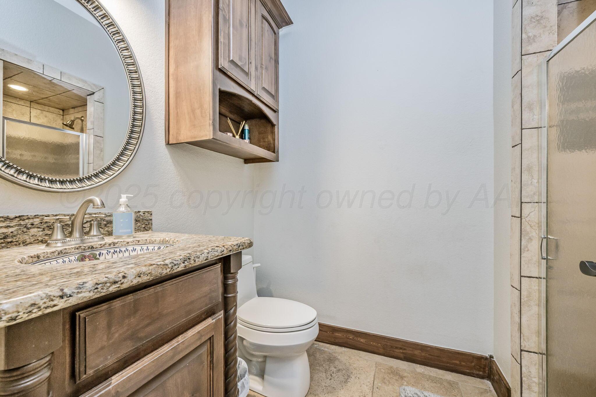 101 Pheasant Run Canyon, TX 79015 - Photo 17 of 39 a bathroom with a granite countertop toilet sink and mirror