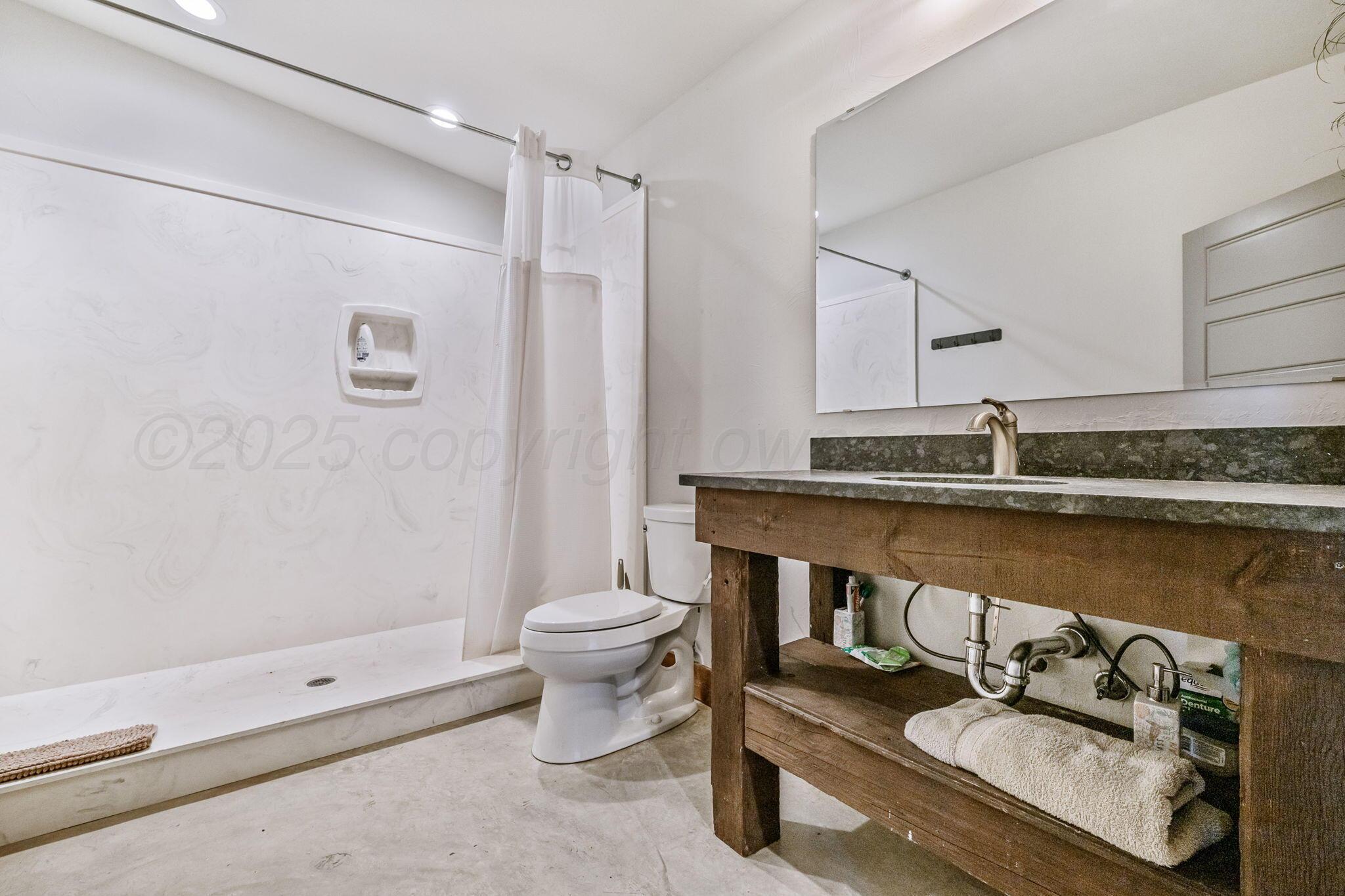 101 Pheasant Run Canyon, TX 79015 - Photo 34 of 39 a bathroom with a granite countertop sink mirror vanity and toilet
