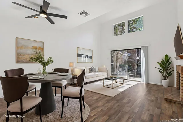 a view of a livingroom and dining room with furniture wooden floor and a chandelier