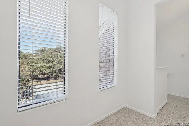 an empty room with a ceiling fan and window