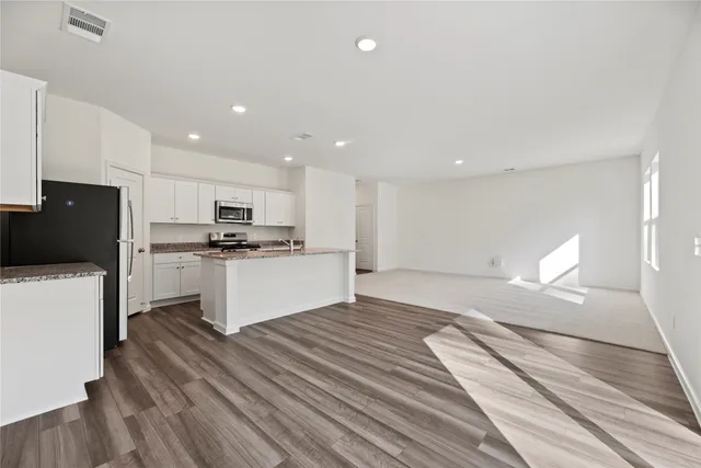 a kitchen with a refrigerator and a stove top oven
