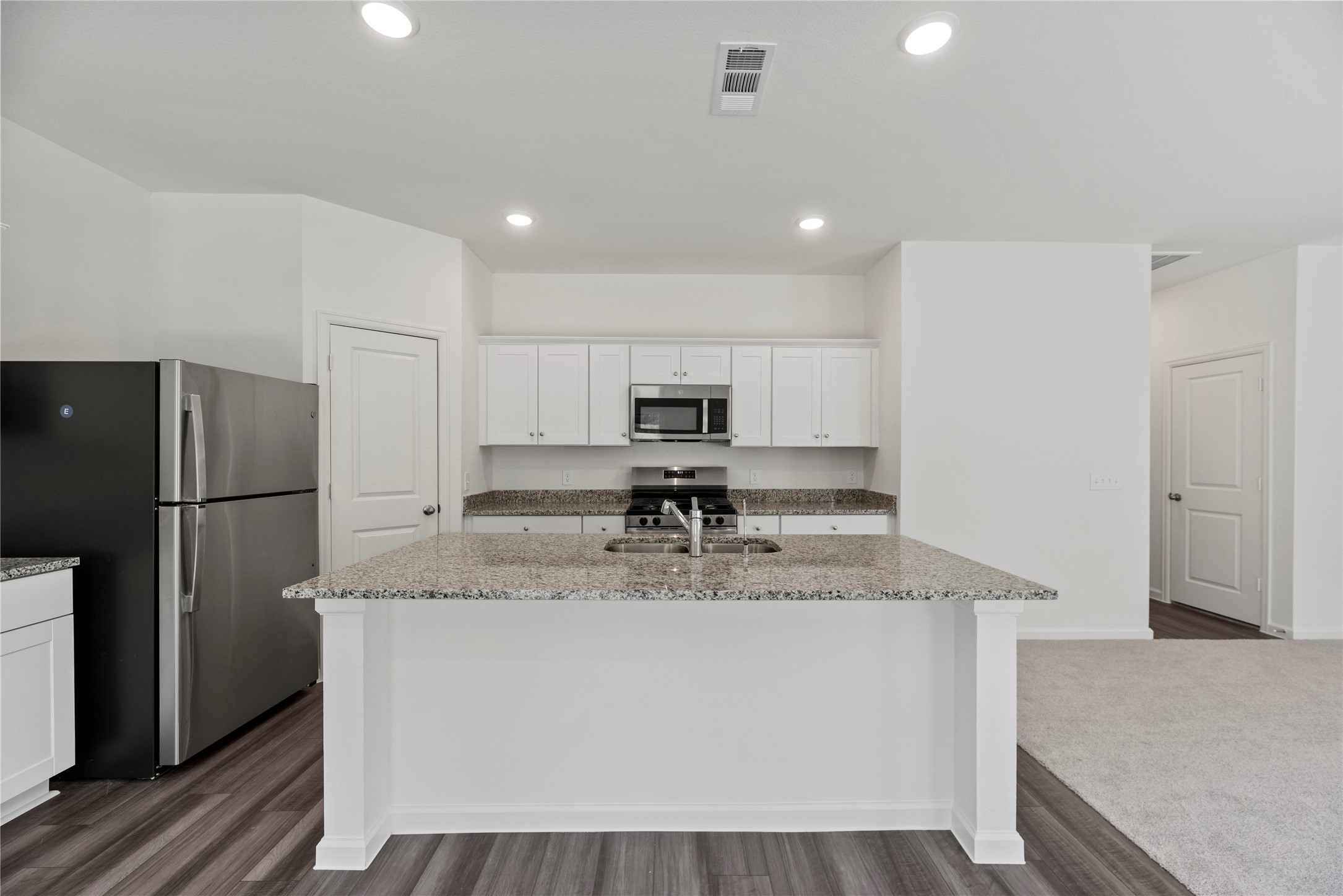 18829 Lucas Michael Way New Caney, TX 77357 - Photo 21 of 40 a kitchen with stainless steel appliances granite countertop a refrigerator a sink a stove a microwave and island