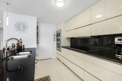 a kitchen with a sink and a clock on the wall