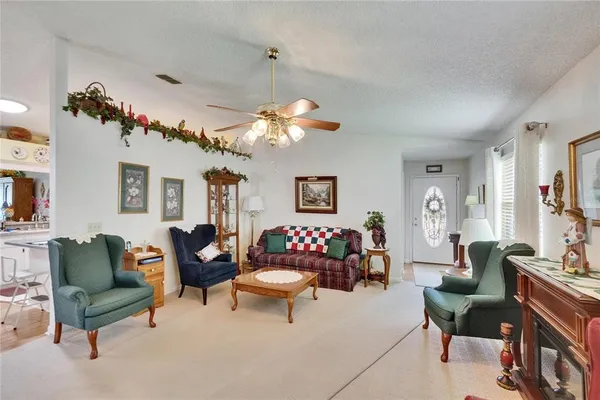a view of living room with kitchen island stainless steel appliances furniture and a window