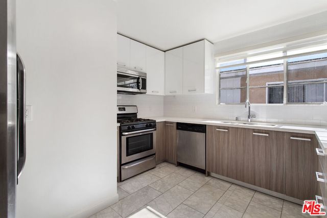 a kitchen with granite countertop a sink and a stove top oven