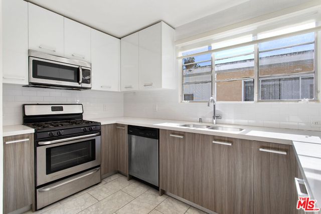 a kitchen with stainless steel appliances granite countertop a sink and a microwave