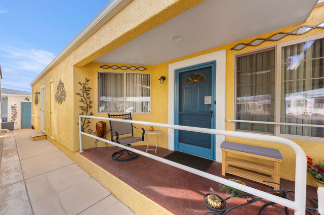 1225 North Dixie Downs Road, Unit 161 St. George, UT 84770 - Photo 16 of 21 Covered entry with a bright yellow stucco exterior, a blue front door, and a white handrail