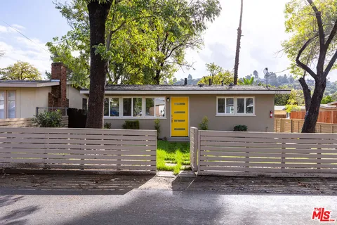 a view of house with a yard and a large tree