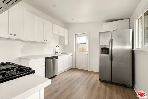 a kitchen with a stove a refrigerator and a sink