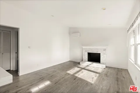 a view of empty room with wooden floor and fireplace