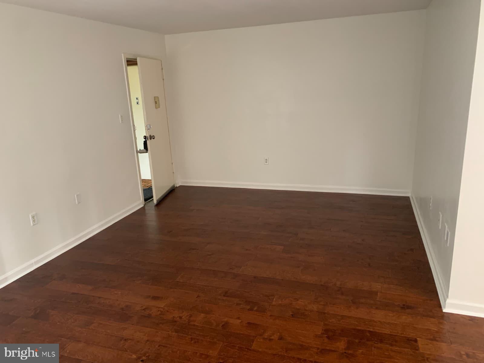 1604 Renate Drive, Unit 104 Woodbridge, VA 22192 - Photo 2 of 29 an empty room with wooden floor and windows