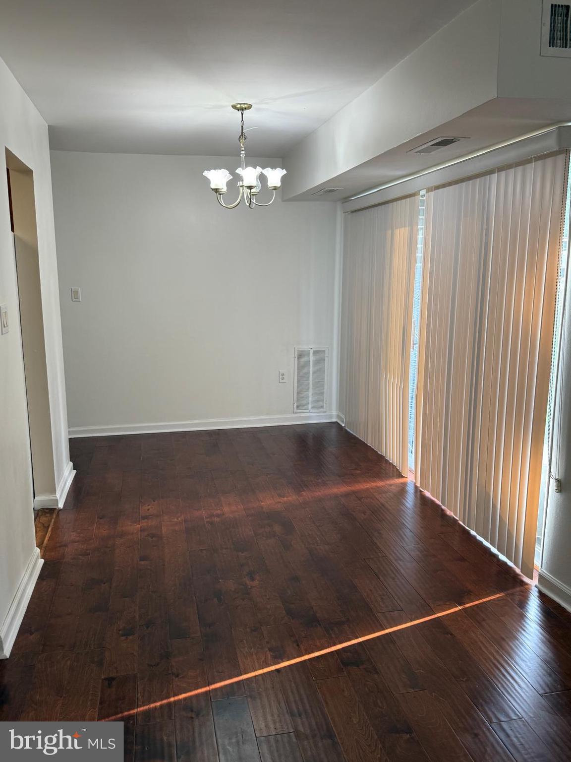 1604 Renate Drive, Unit 104 Woodbridge, VA 22192 - Photo 7 of 29 an empty room with wooden floor chandelier and entryway