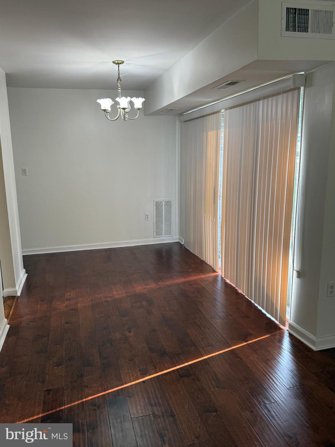 1604 Renate Drive, Unit 104 Woodbridge, VA 22192 - Photo 8 of 29 an empty room with wooden floor chandelier fan and windows