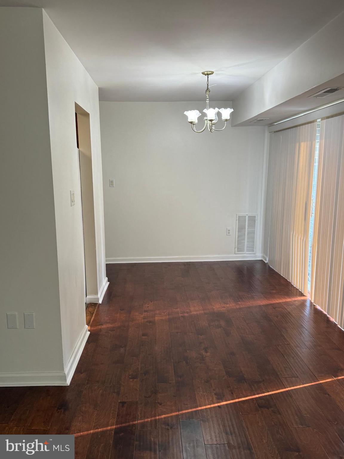 1604 Renate Drive, Unit 104 Woodbridge, VA 22192 - Photo 9 of 29 an empty room with wooden floor and chandelier