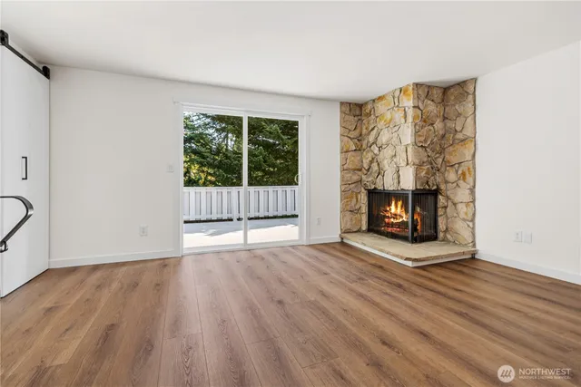 a view of empty room with wooden floor and fireplace