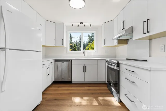 a kitchen with a stove cabinets and a window