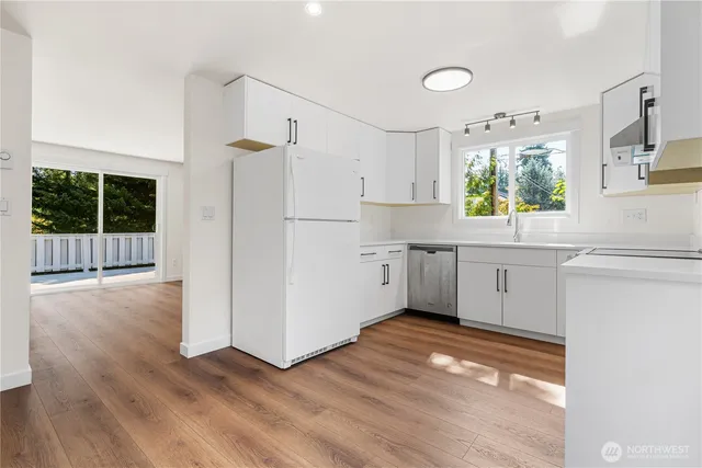 a kitchen with stainless steel appliances a refrigerator sink and cabinets