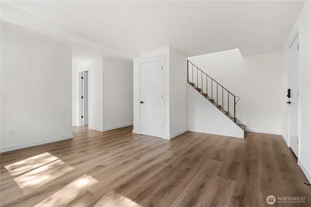a view of an empty room with wooden floor