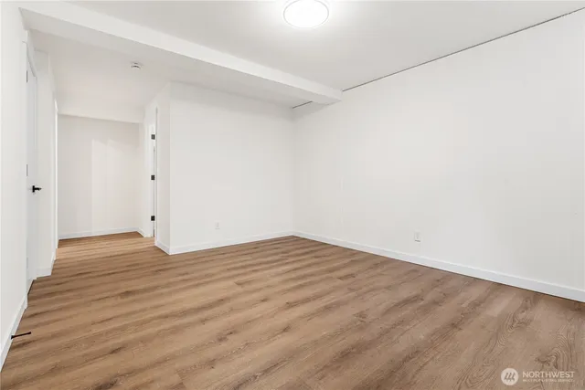 a view of empty room with wooden floor
