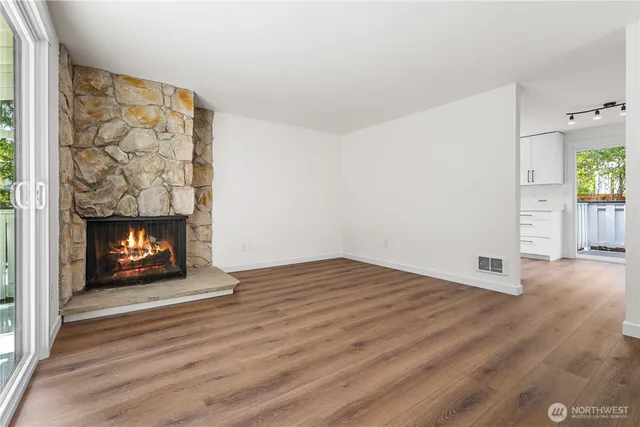 a view of empty room with wooden floor and fireplace