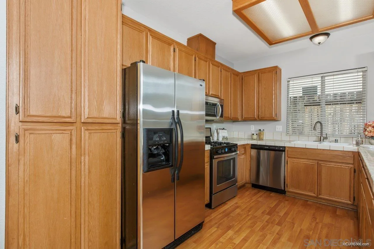 1867 McDougal Terrace El Cajon, CA 92021 - Photo 8 of 28 a kitchen with stainless steel appliances granite countertop a refrigerator and a sink