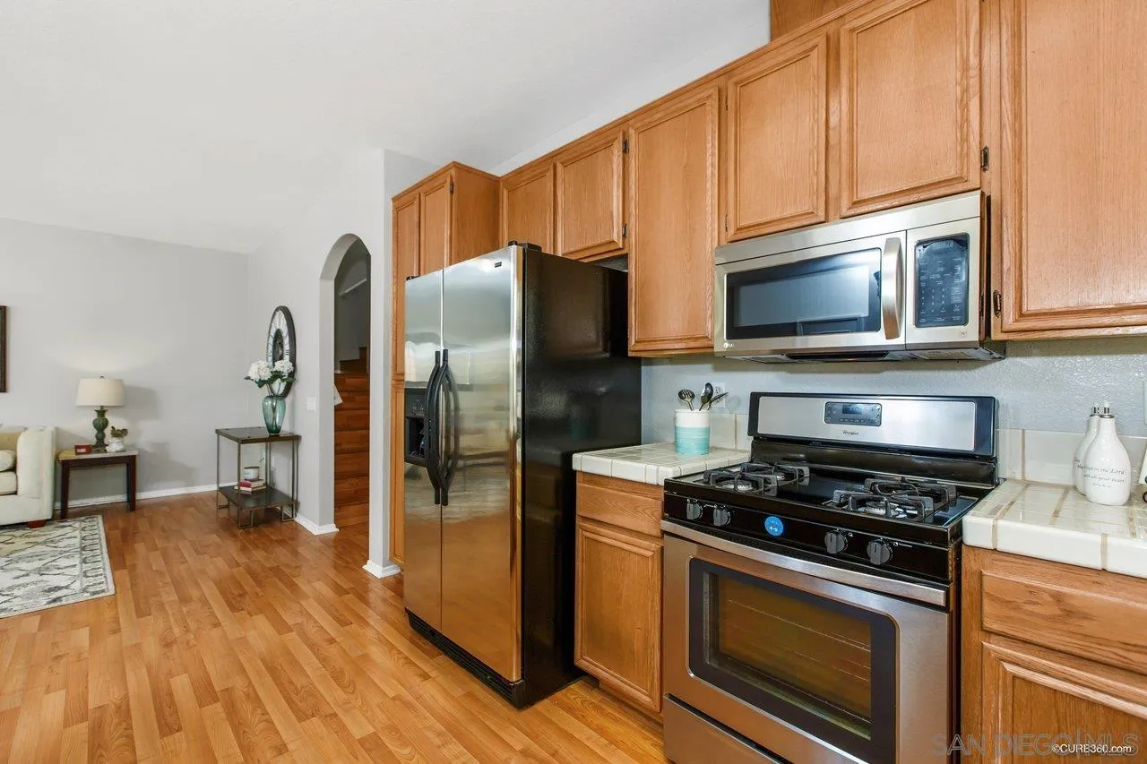 1867 McDougal Terrace El Cajon, CA 92021 - Photo 9 of 28 a kitchen with granite countertop a refrigerator stove and microwave