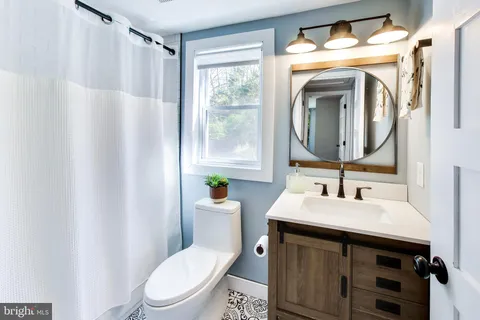 a bathroom with a toilet a sink and a mirror