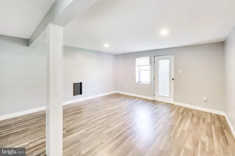 a view of an empty room and window and wooden floor