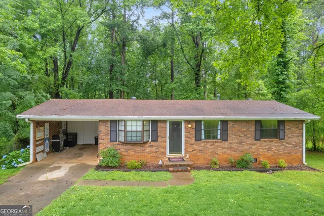 a front view of a house with a garden and yard