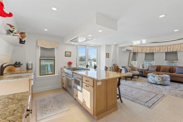 a large kitchen with kitchen island a large counter space a sink appliances and cabinets
